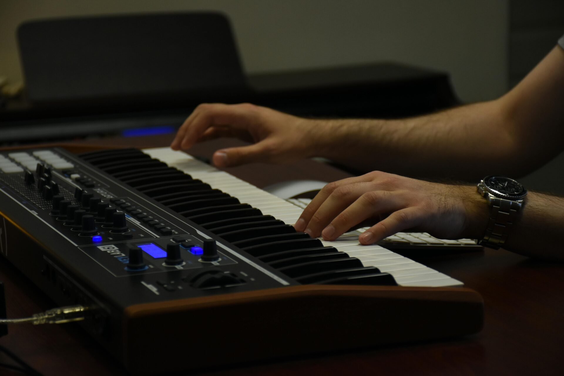 Music producer playing a synth keyboard.